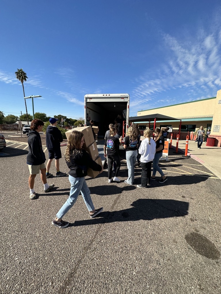Volunteers carrying boxes from a uhaul truck