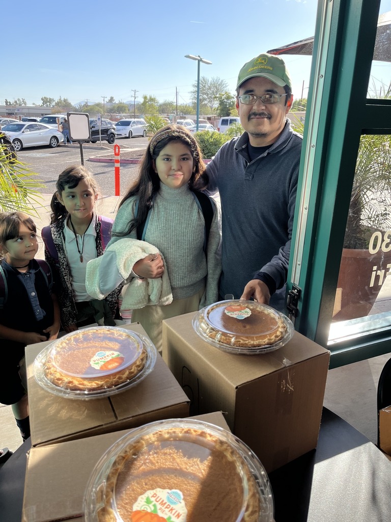 Father and 3 daughters collecting a thanksgiving box and pies