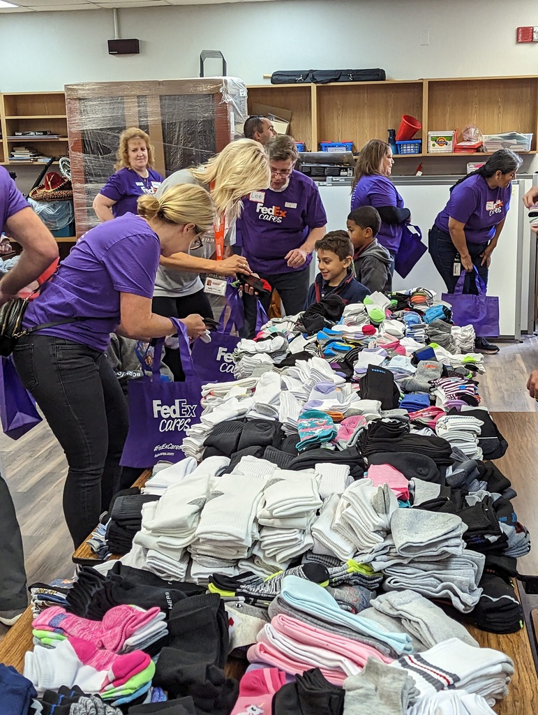 FedEx employees helping students pick out socks